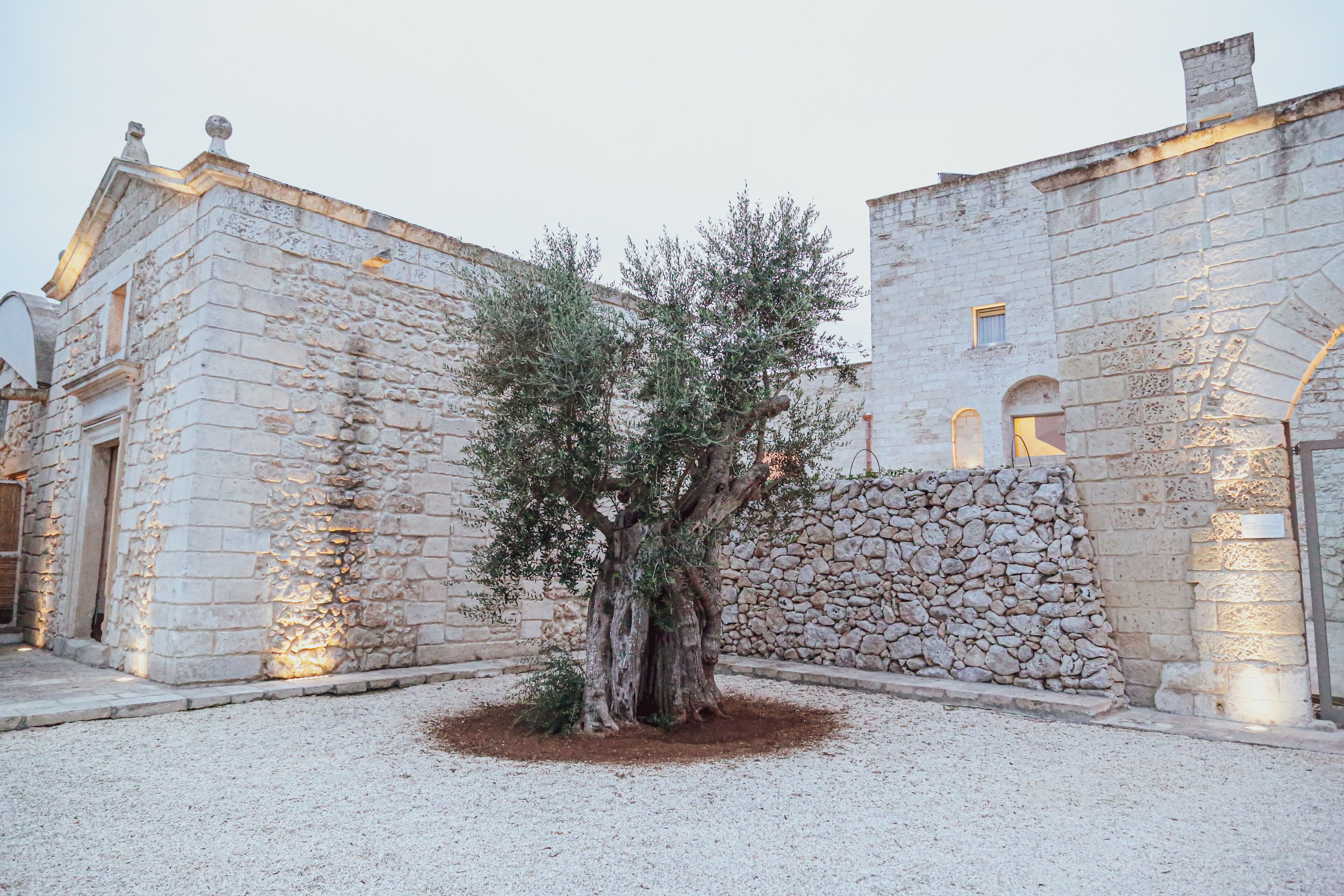 A stone building with a tree in front.