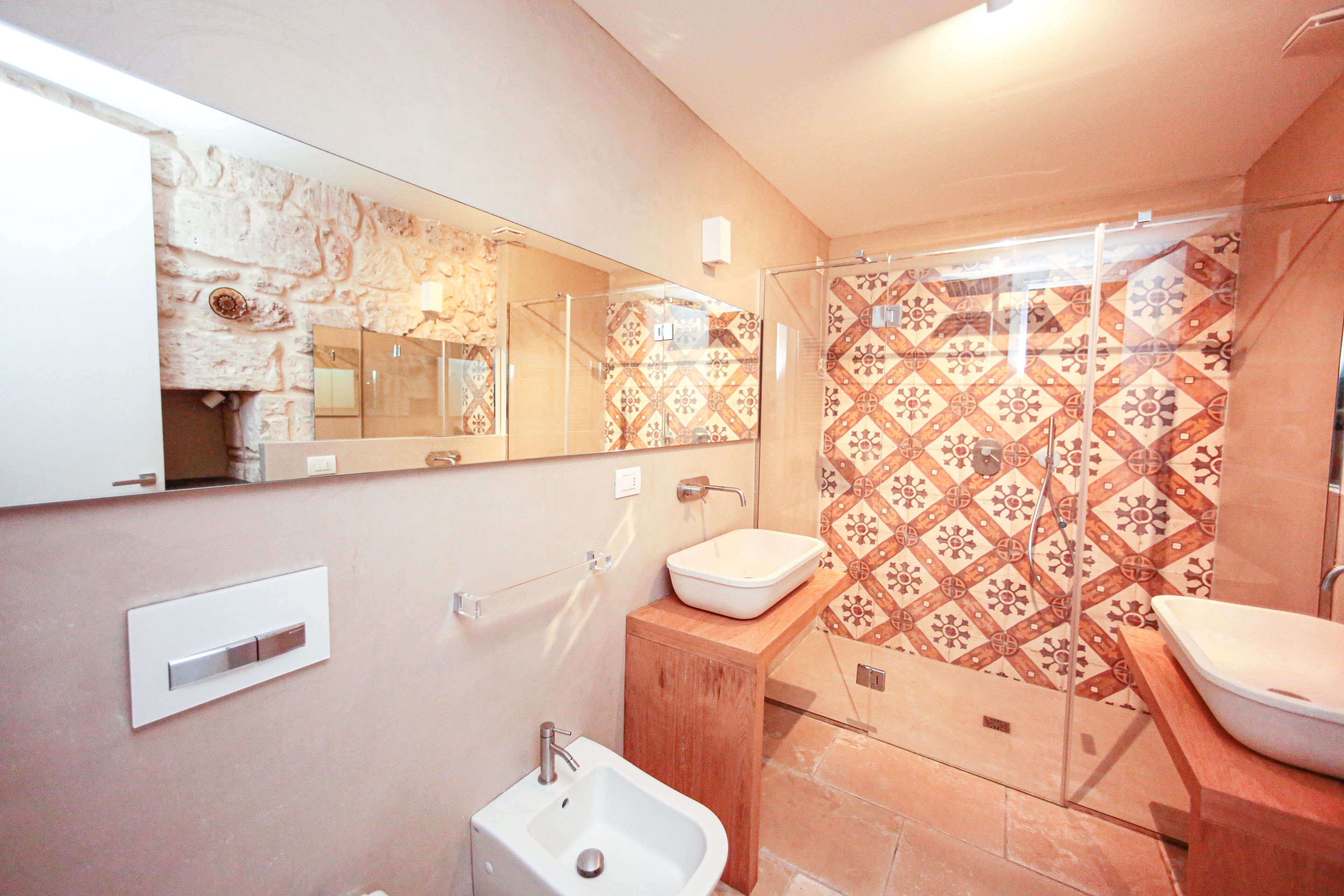 Un bagno con uno specchio grande, un lavandino e una doccia.