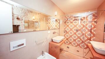 Un bagno con uno specchio grande, un lavandino e una doccia.