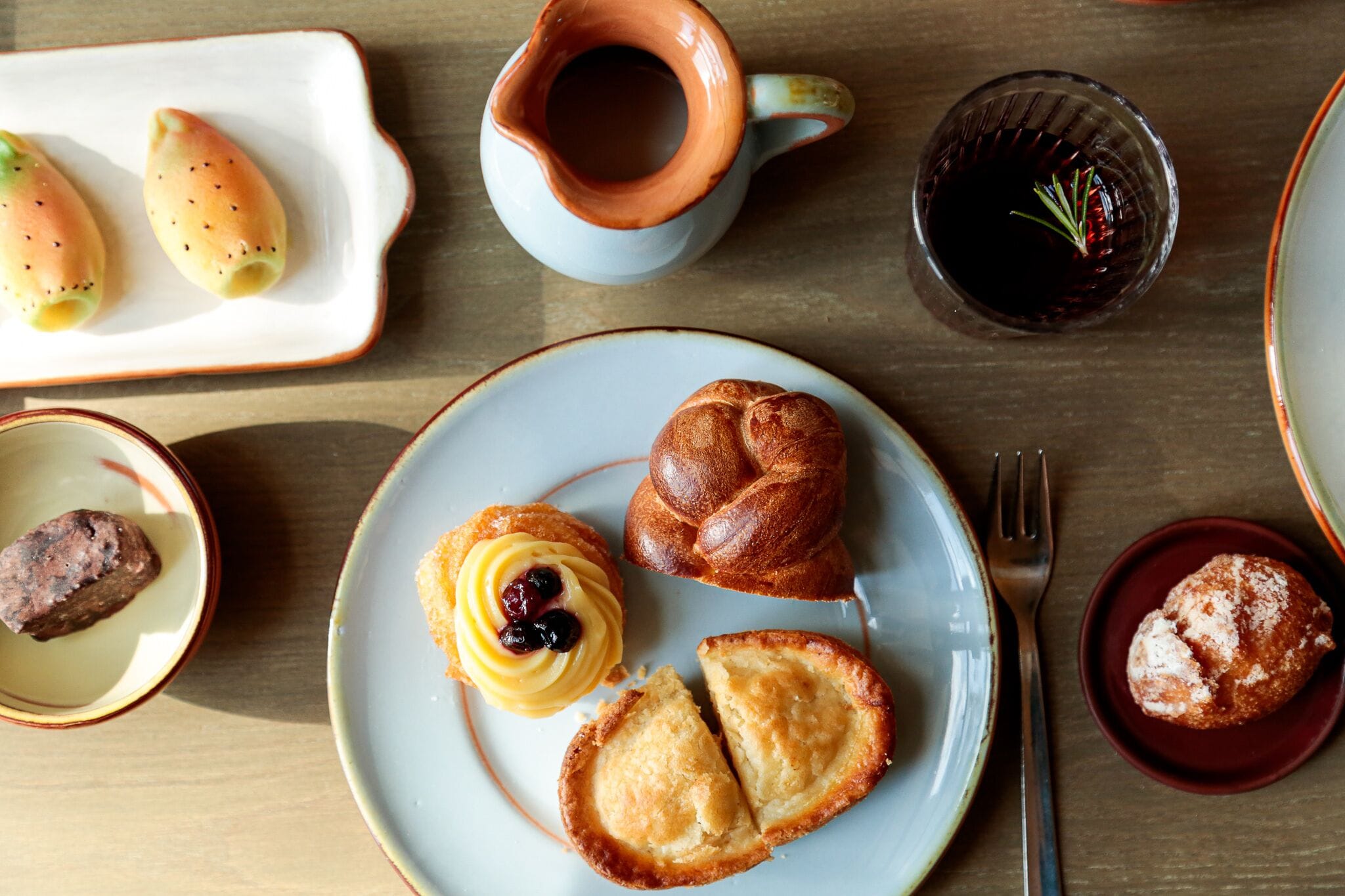 A table with various pastries and a coffee cup.