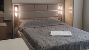 A neatly made bed with a patterned bedspread and a folded white pillow. - House by the sea Kaprovani Shekvetili Batumi (Ureki)