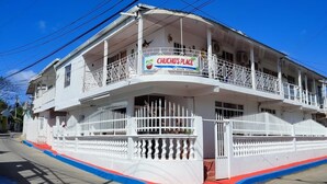 Un edifici de dues plantes amb un cartell que diu "CHUCHO'S PLACE" i una valla blanca que envolta la propietat.
