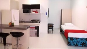 Habitació senzilla amb bugateria, llit i taula petita.