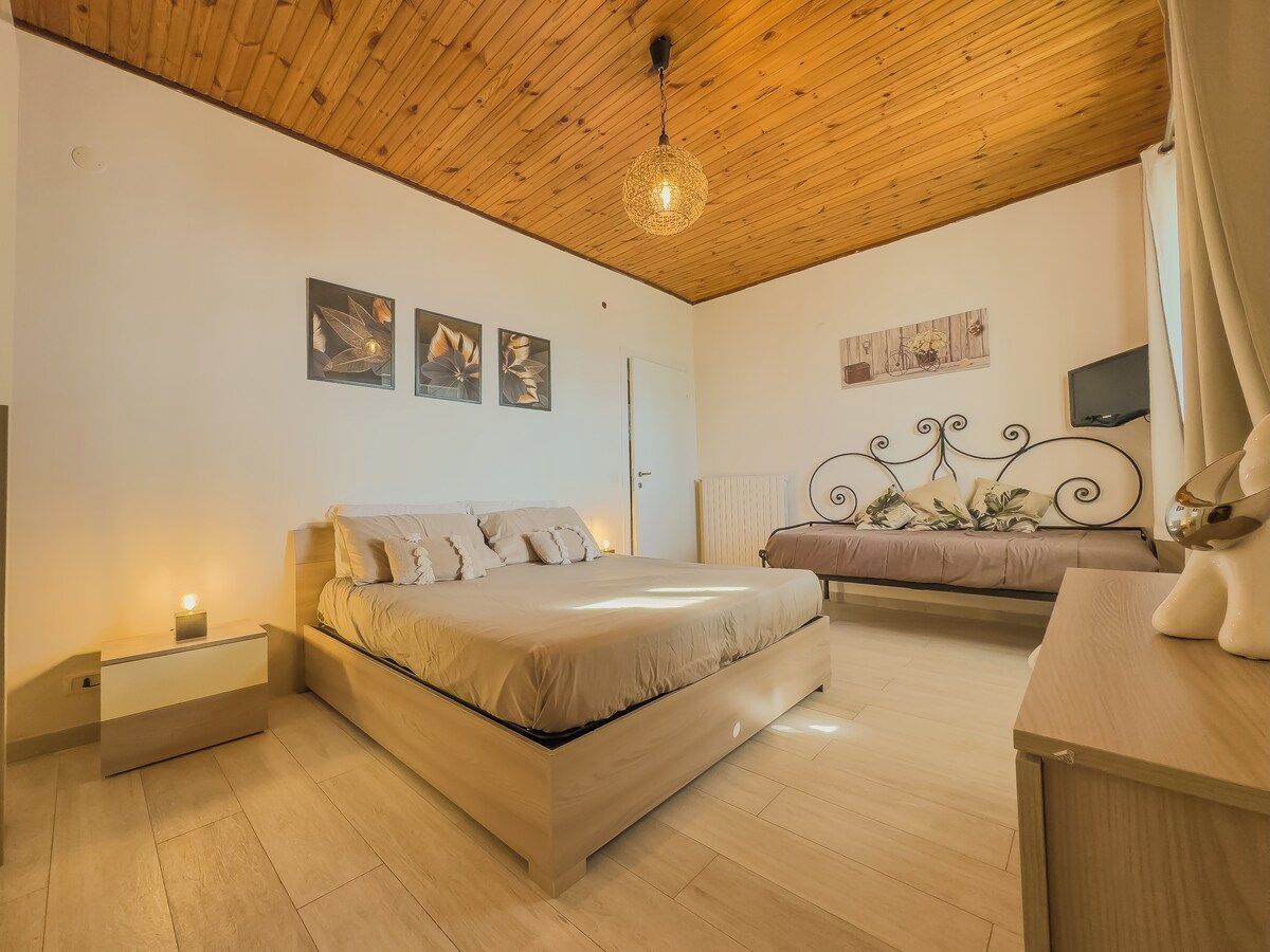 Une chambre à coucher comprenant un lit, une table de chevet et un élément décoratif mural.