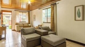 A cozy living area with a wooden ceiling, a sofa set, and a framed botanical print on the wall. - Tikita family house in La Fortuna downtown (La Fortuna)