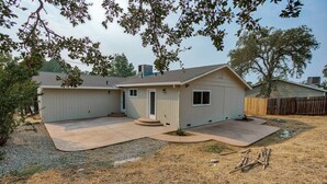 Une maison de plain-pied dotée d’un patio couvert, d’un petit garage attenant et d’une cour arrière clôturée.