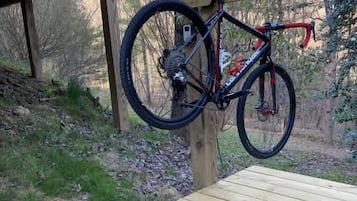 A wooden deck with a bicycle leaning against a post.