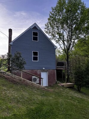 Une maison à deux étages avec une cheminée, un garage et un petit porche.