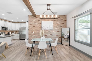 Enjoy meals in this well-equipped kitchen with a brick accent wall, white cabinetry, and stainless steel appliances.