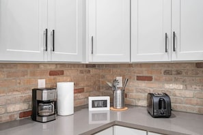 Enjoy cooking in this well-equipped kitchen with a coffee maker, toaster, and utensil holder.