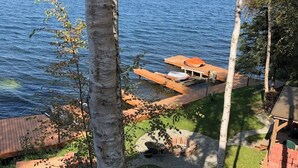 Una propiedad frente al lago con muelle de madera, un pequeño espacio de estar al aire libre y vistas al lago.