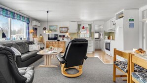 Un salon moderne avec un canapé, une table ronde et un fauteuil de bureau noir.