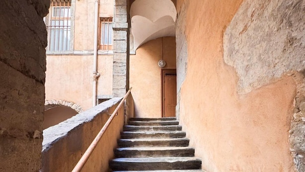 A stone staircase in a narrow corridor with a door at the top. - Opéra 8 - Lovely fully equipped studio - Opéra (Lyon)