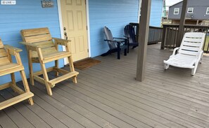 Relax on the deck with comfortable seating options, including two chairs and a lounge chair.