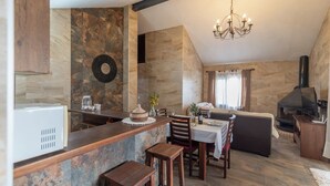 Eine moderne Küche mit Steinrückwand, Holzschränken und einem eingebauten Herd.