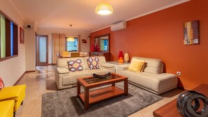 A living room with a sofa, coffee table, and a lamp. There is a window and a door leading to another room. - Porto Residence Campanhã (Oporto)