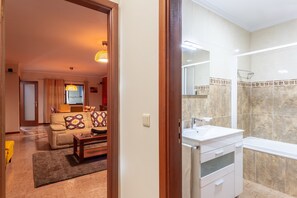 A modern bathroom with a large mirror, a sink, and a shower area. - Porto Residence Campanhã (Oporto)