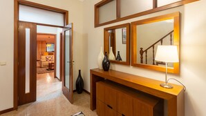 A hallway with a wooden console table, a mirror, and a lamp. - Porto Residence Campanhã (Oporto)