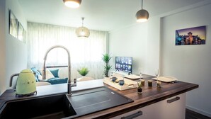Une cuisine moderne dotée d’un évier, d’un plan de travail et de luminaires suspendus.