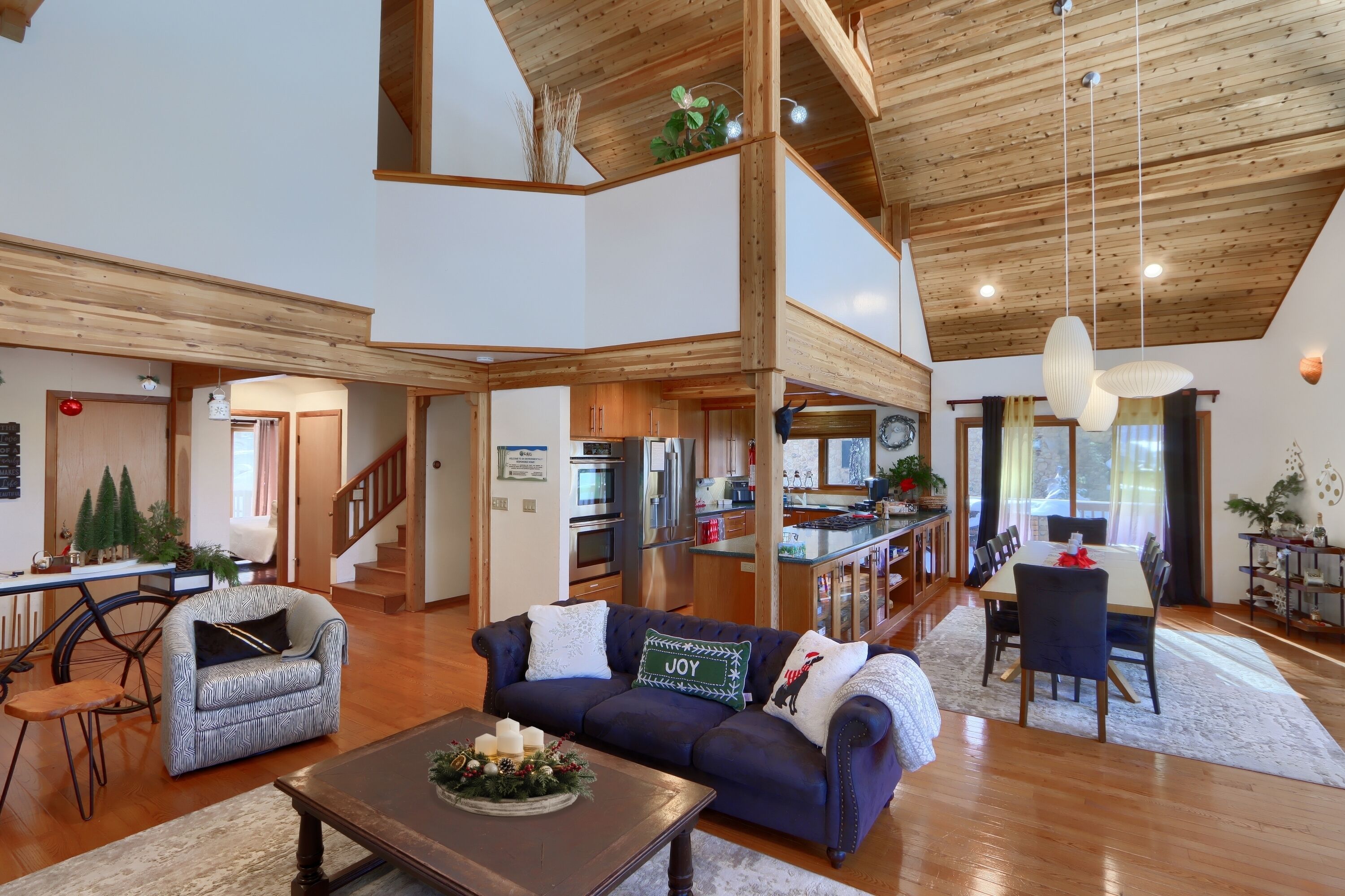 Open living, kitchen, and dining space with soaring ceilings and warm flow!