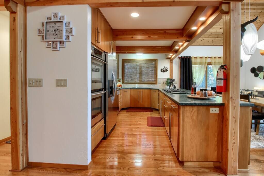 Una cocina moderna con armarios de madera, electrodomésticos de acero inoxidable y una isla central.