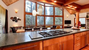 Una cocina moderna con una isla grande, armarios de madera y un comedor con mesa y sillas.