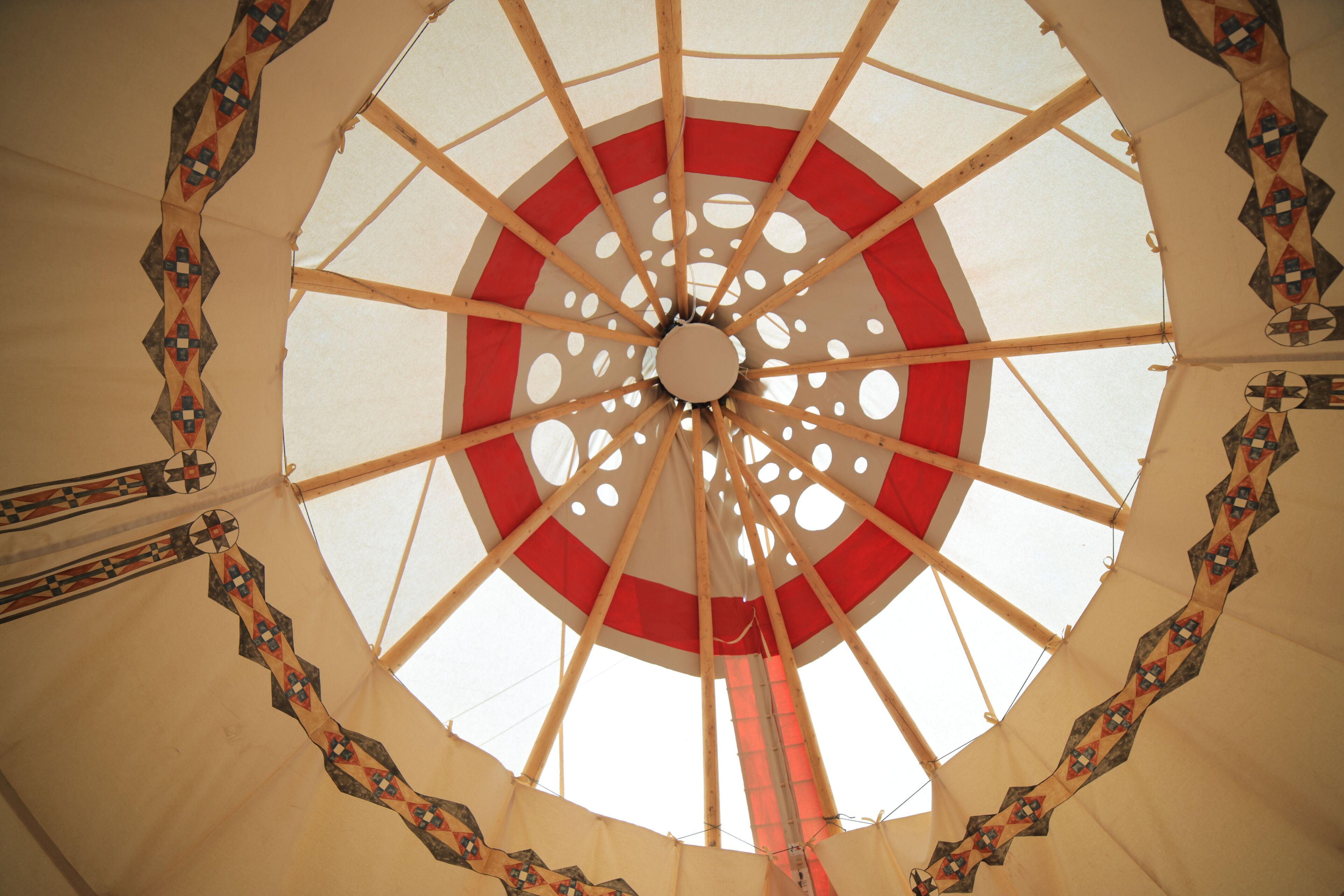A tent with a circular design and a central pole.