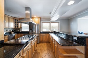 A modern kitchen with granite countertops, stainless steel appliances, and wooden cabinetry. - Home in Linden (Linden)