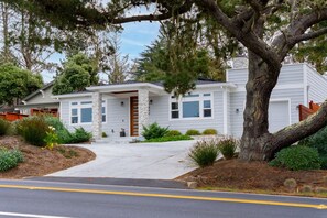 A single-story house with a stone facade, a front porch, and a driveway leading to the entrance.