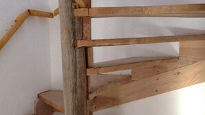 A wooden spiral staircase with a rustic design, made of natural wood planks. - CERRO CATEDRAL SCHUSS ARG41 (San Carlos de Bariloche)