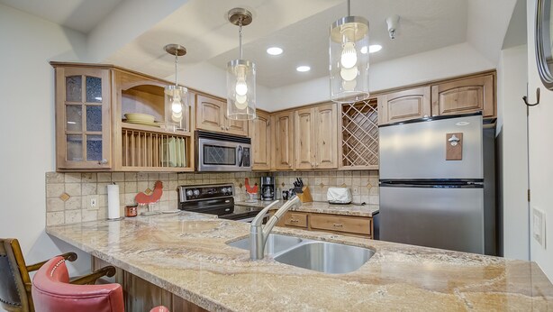 A kitchen with granite countertops, stainless steel appliances, wooden cabinets, and pendant lighting. - Empire Coalition Ski Condo - Walking distance to PC Mtn - Free bus route (Park City)