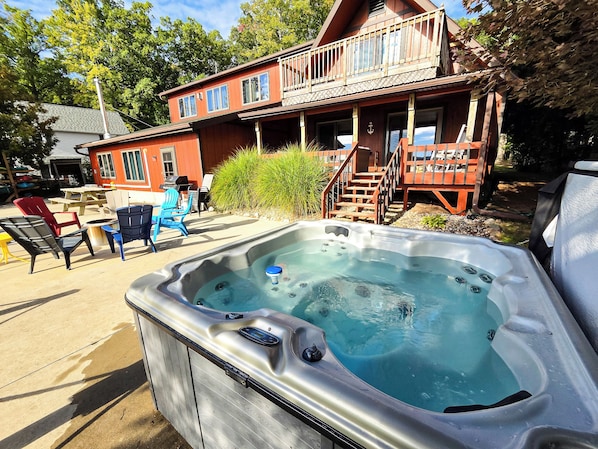 Un jacuzzi frente a una casa de madera con balcón.