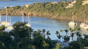 Uma vila costeira com um porto, barcos e casas numa encosta.