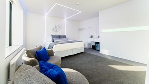 A modern bedroom with a bed, a desk, and a chair. - Quarters A2- Luxurious studio (Dunedin)