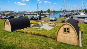 A marina with boats, a parking area, and two wooden huts.