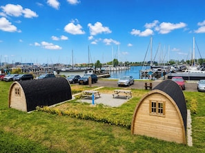 A marina with boats, a parking area, and two wooden huts.