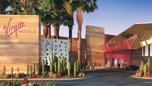 A hotel entrance with a sign reading "Virgin Hotels," palm trees, and cacti in the foreground. - Beautiful Hotel 2 mins from the strip-The Virgin Hotel- (Las Vegas)