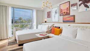 A hotel room with two beds, a small table, and artwork on the wall. - Beautiful Hotel 2 mins from the strip-The Virgin Hotel- (Las Vegas)