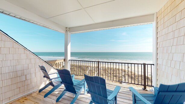 A covered deck with blue chairs overlooking a beach. - Beachfront Paradise | Poolside Escape | Perfect Spring Break Vacation | Margartia Villas A (North Myrtle Beach)