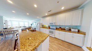 A modern kitchen with white cabinets, granite countertops, and stainless steel appliances. - Beachfront Paradise | Poolside Escape | Perfect Spring Break Vacation | Margartia Villas A (North Myrtle Beach)