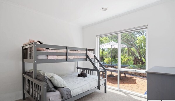 A bunk bed room with a view of the garden through large windows. - Tuscan style ocean beach escape on the Peninsula (Saint Andrews Beach)