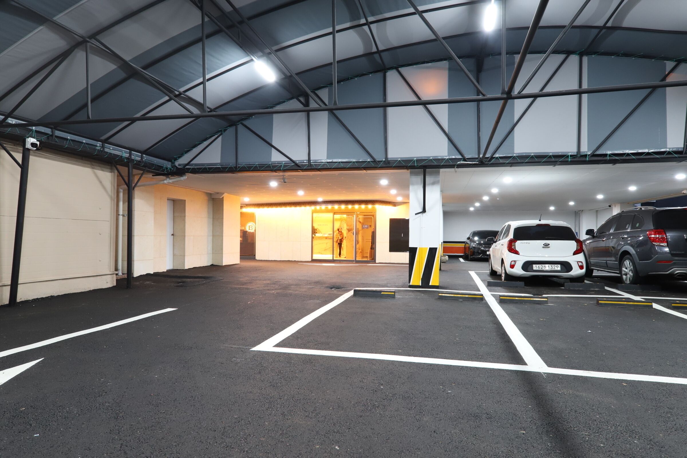 Ein überdachter Innenparkplatz mit ausgewiesenen Stellplätzen.