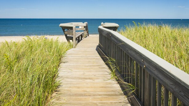 A wooden boardwalk leading to a beach with a clear view of the ocean. - Oceanfront Property with AC in Scorton Shores (East Sandwich)
