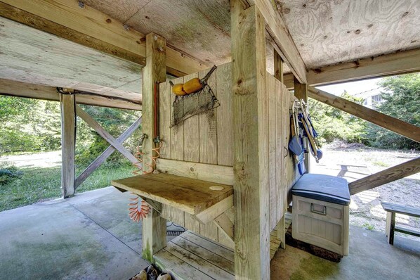A rustic wooden cabin with a wooden bench, a small table, and a utility box.