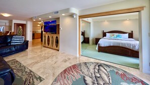 A spacious living area with a large flat-screen TV, a comfortable sofa, and a patterned rug. - Oceanfront spacious 1bd Maalaea condo (Wailuku)