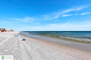 Een strand met heldere lucht, een zandstrand en enkele strandspullen.