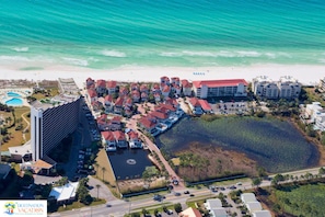 Ein Resort mit mehreren Gebäuden, einem Swimmingpool und einem großen Gewässer.