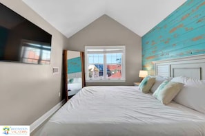 Een slaapkamer met een groot bed, een raam en uitzicht op een gebouw.