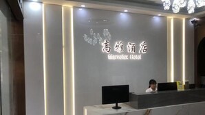 Ein Hotelrezeptionstresen mit Marmorplatte und einem digitalen Bildschirm. Der Empfangsbereich besticht durch ein modernes Design mit vertikalen Lichtakzenten.