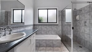 Un baño moderno con lavamanos, bañera y cabina de ducha de vidrio.